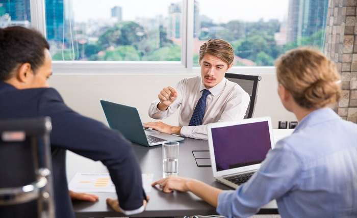 businessman sitting with laptop talking other colleagues 1262 808