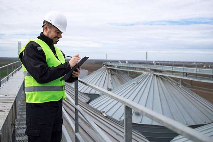 portrait construction worker standing rooftops high silos storage tanks working tablet computer 342744 441